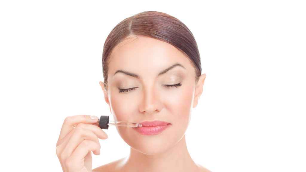 Happy woman applying lip oil