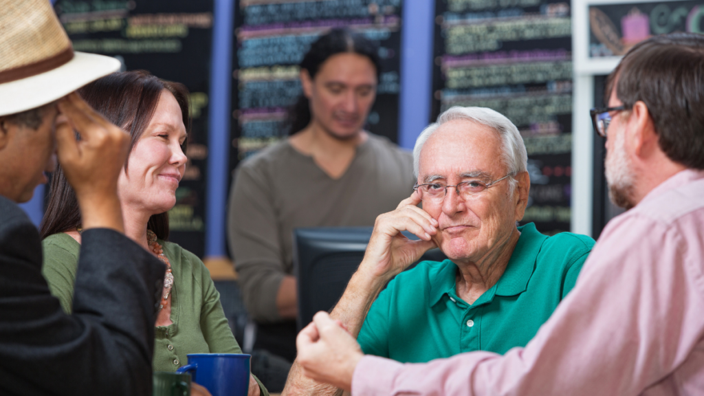 Bored older man at table with friends
