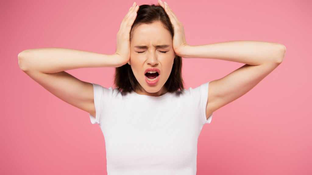 woman with hands on head and eyes closed