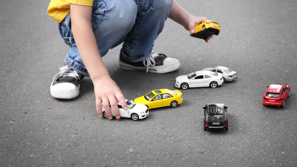 child playing with toy cars