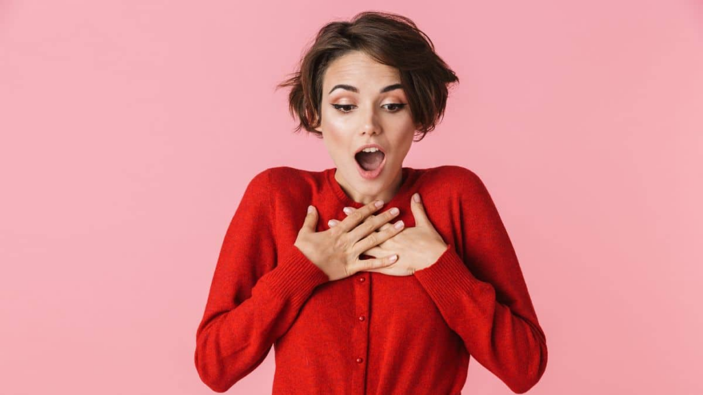 woman looking surprised with her hands on her chest