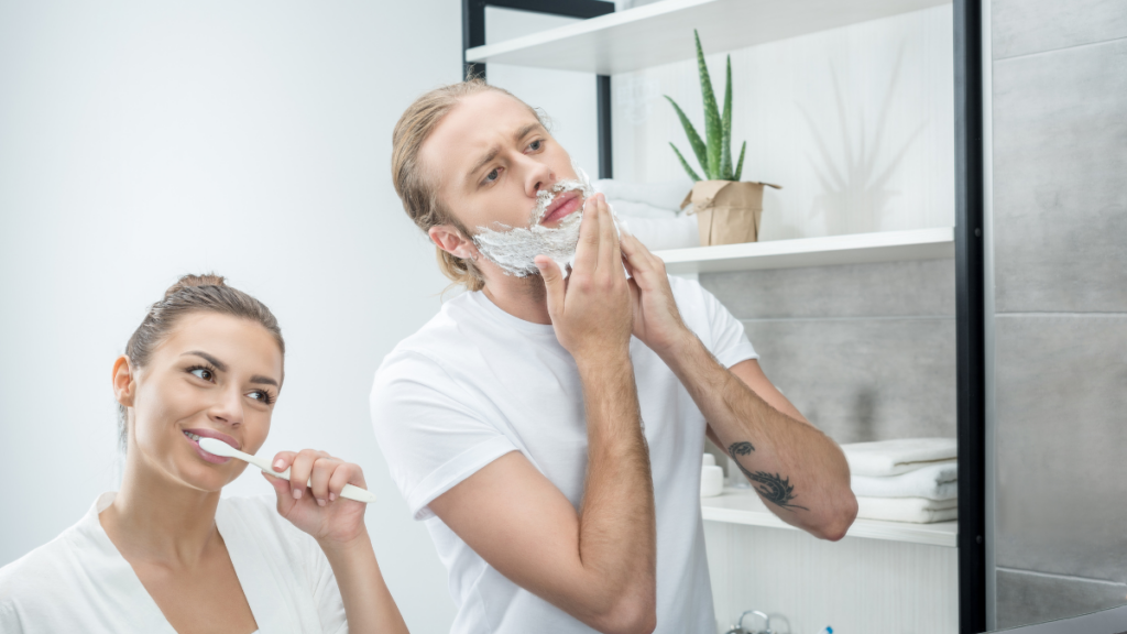 man and woman brushing their teeth