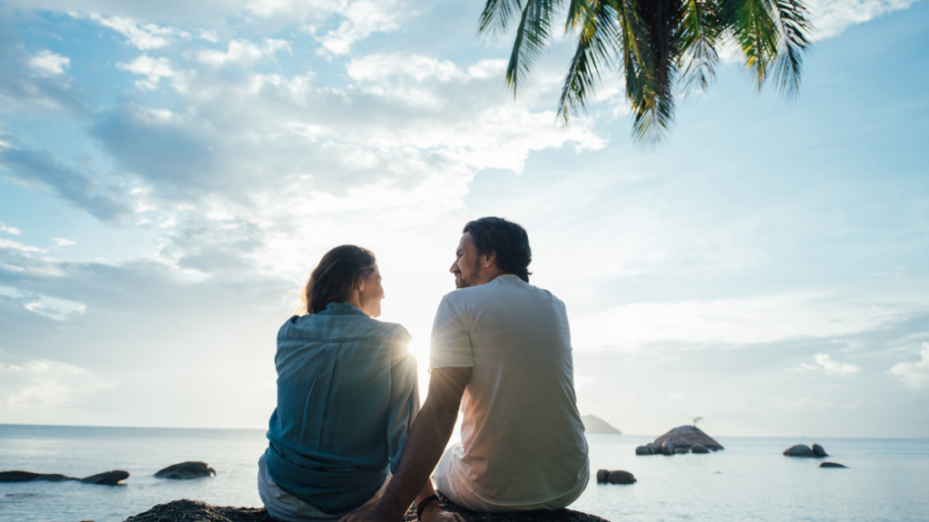 man and woman looking at ocean