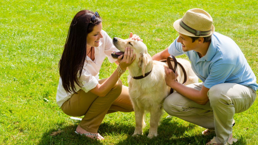 man and woman petting a dog