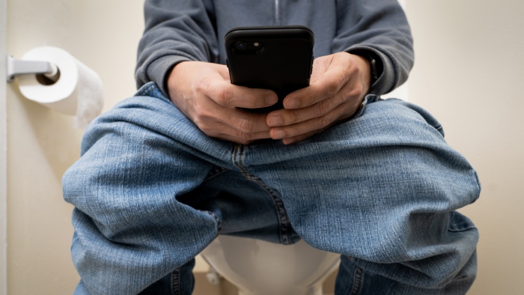 man on phone on toliet