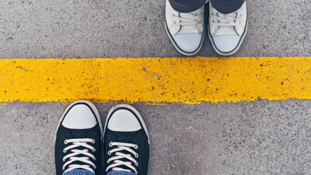 two sets of feet on sides of a yellow line